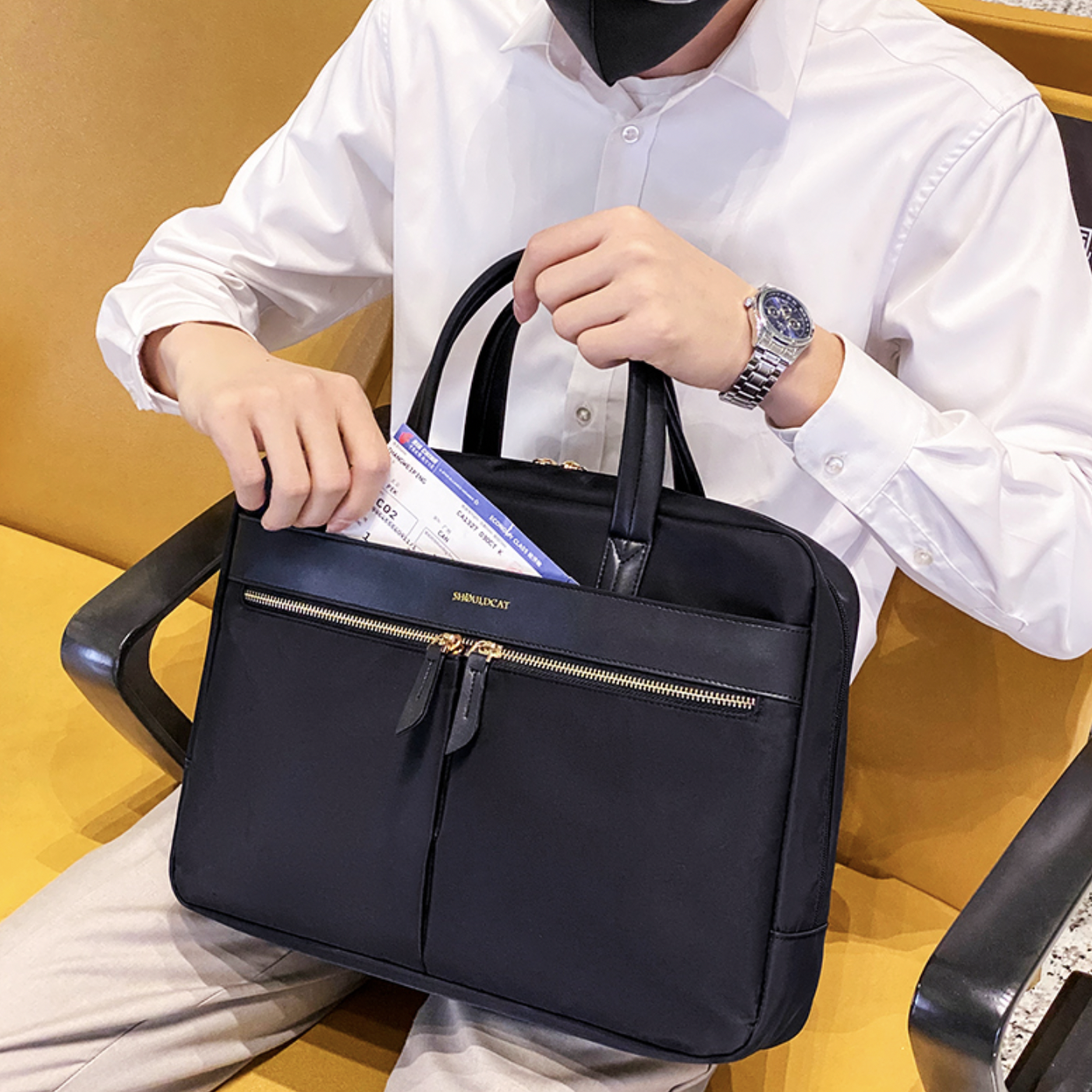 Sacoche porte document noire à bandoulière pour homme dans un aéroport