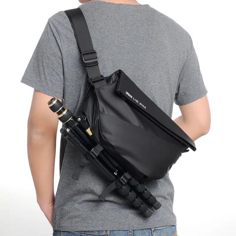 Sacoche appareil photo étanche noire avec bandoulière portée par un homme